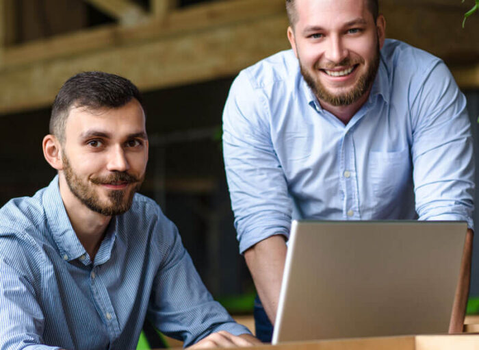 picture-handsome-businessman-listening-his-colleague-partner-concerning-ner-business-system-while-working-laptop-computer-office-interior